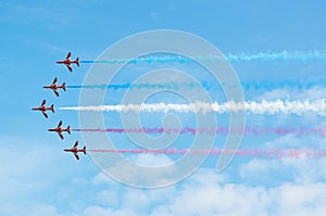 EASTBOURNE, ENGLAND - AUGUST 14, 2015: RAF aerobatic team The Red Arrows perform at the Airbourne airshow.The smoke trails left by