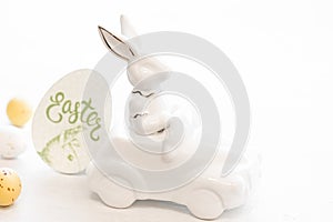 Easter background with a ceramic hare in the car and eggs on a white background,