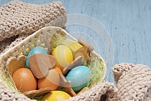 Easter background with colored eggs and cookies basket