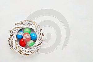 Easter background. Colorful Easter eggs in wreath on white background. Top view, copy space