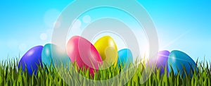 Easter Background With Colorful Eggs In Green Grass Over Blue Sky Horizontal Banner