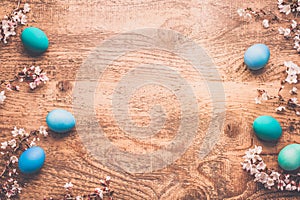 Easter background with colorful eggs in nest on wooden background