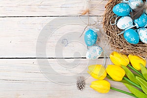 Easter background with colorful eggs and yellow tulips