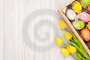 Easter background with colorful eggs and yellow tulips