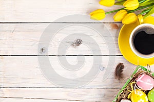 Easter background with colorful eggs and yellow tulips