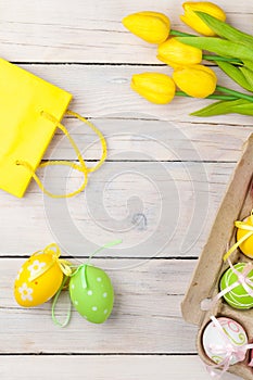 Easter background with colorful eggs and yellow tulips