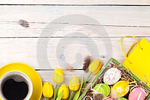 Easter background with colorful eggs and yellow tulips