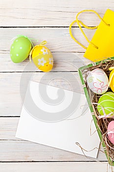 Easter background with colorful eggs, yellow tulips and greeting