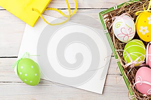 Easter background with colorful eggs, yellow tulips and greeting