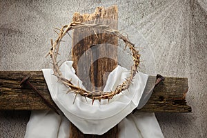 Easter background depicting the crucifixion with a rustic wooden cross, crown of thorns and nails.