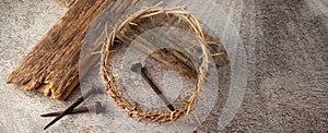 Easter background depicting the crucifixion with a rustic wooden cross, crown of thorns and nails.