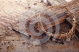 Easter background depicting the crucifixion with a rustic wooden cross, crown of thorns and nails.