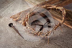 Easter background depicting the crucifixion with a rustic wooden cross, crown of thorns and nails.