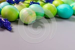 Easter background of green and blue eggs in harmony with the natural shades of flowers