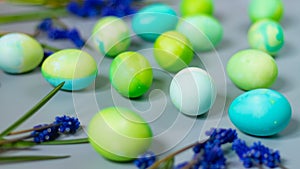 Easter background of green and blue eggs in harmony with the natural shades of flowers