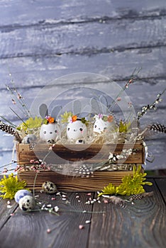 Easter background, homemade eggshell bunnies and yellow chrysanthemum in wooden box