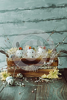 Easter background, homemade eggshell bunnies and yellow chrysanthemum in wooden box