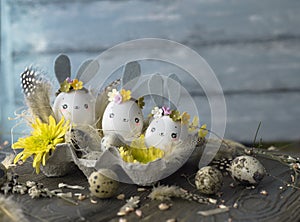 Easter background, homemade eggshells rabbits and yellow chrysanthemum in cardboard boxes