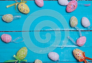 Easter background. Multicolored decorated easter eggs, multi-colored powder on a turquoise background. Free space