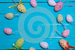 Easter background. Multicolored decorated easter eggs, multi-colored powder on a turquoise background. Free space