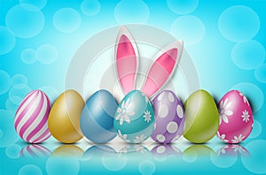 Easter background with painted 3d realistic egg and bunny ears behind on blue backdrop with bokeh. photo