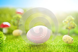 Easter background with pink Easter eggs on green grass in pastel colors in spring of Dreamland or fairy world