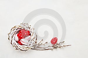 Easter background. Red and white Easter eggs in wreath on white concrete background. Top view, copy space