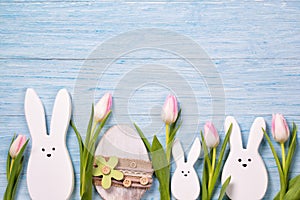 Easter background with white rabbits, pink tulips and easter egg, top view