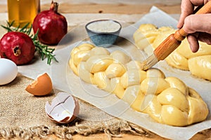 Easter baked goods, challah or zopf buns. Proof before placing in the oven. Brush on butter buns before baking. Close-up. Braided