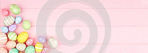 Easter banner with corner border of pastel Easter Eggs over a pink wood background with copy space
