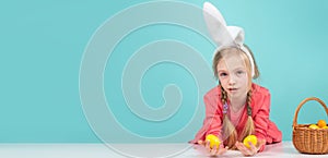 Easter banner. Cute girl in bunny ears on Easter day. Girl holding painted eggs.