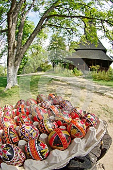 Easter. Hand painted eggs and traditional orthodox wooden church Barsana Monastery - landmark attraction in Maramures, Romania