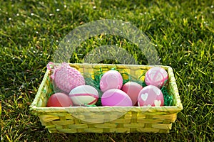 Easter basket with coloured Easter eggs on the lawn with space for additional text.