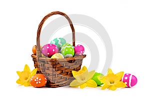 Easter basket with eggs and daffodils over white