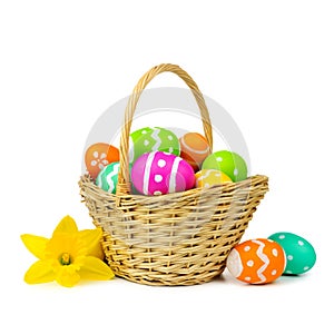 Easter basket with eggs and daffodils over white