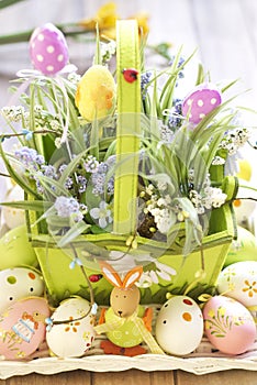 Easter basket with eggs, flowers and Easter bunny