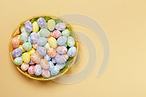 Easter basket of eggs on a yellow background with space for text. Top view copy space