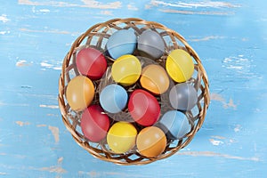 easter basket with straw and colored eggs