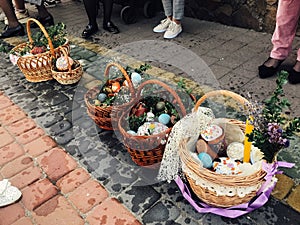 Easter baskets with stylish painted eggs, easter cake, ham,beets, butter, candle with boxwood branches for sanctify at church on