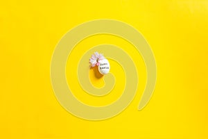 Easter beautiful flat lay with one egg in center with text and copy space on yellow background