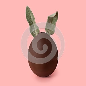 Easter black chocolate bunny over pink background,  creative art concept, close up