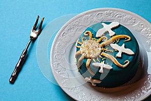 Easter blue cake, yellow sun and white doves in the white plate with fork. Blue background.