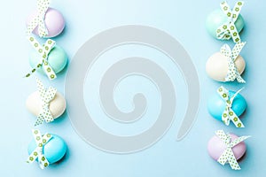 Easter border. Colorful egg with tape ribbon on pastel blue background in Happy Easter decoration. Flat lay, top view