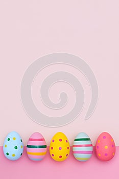 Easter border of vivid Easter eggs on a pink background.