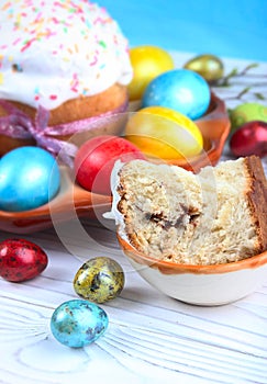 Easter bread and colorful eggs on a wooden, white background.