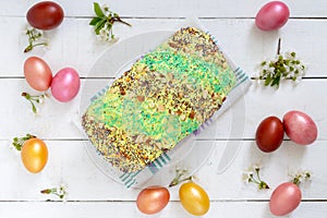 Easter bread kulich with glaze, colorful sugar sprinkles. Colored painted eggs.