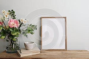 Easter breakfast still life. Blank picture frame mockup. Wooden bench, table composition with cup of coffee, old books