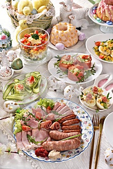 Easter breakfast with traditional sausage and cold cuts, deviled eggs and salads on festive table