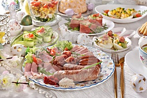 Easter breakfast with traditional sausage and cold cuts, deviled eggs and salads on festive table