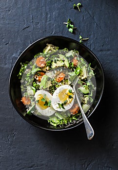 Easter brunch quinoa, eggs, avocado, cucumber, carrot salad on dark background, top. Healthy vegetarian food concept